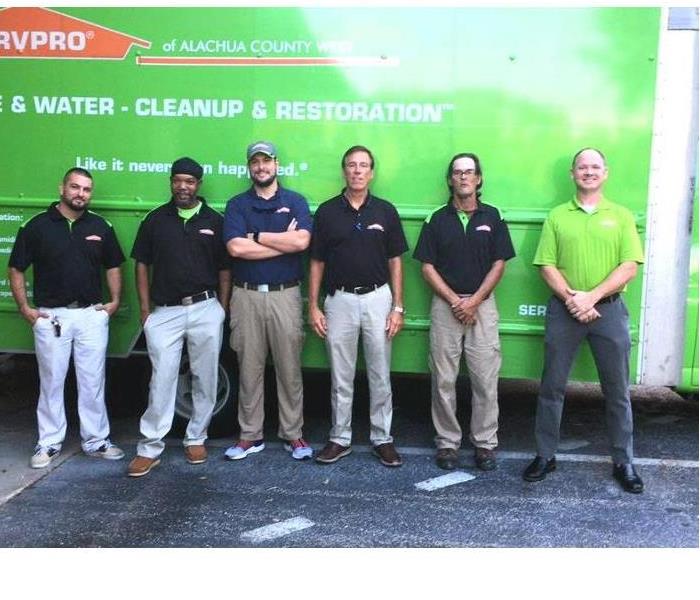 The SERVPRO Gainesville West/Alachua County West restoration technicians & marketer standing in front of truck